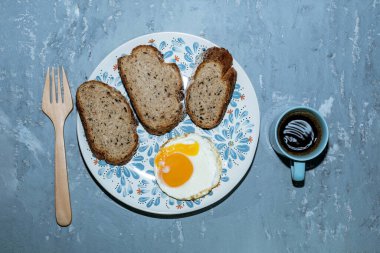 Tabakta kızarmış yumurta dilimi gri arka planda izole edilmiş espresso kahvesi var. Üst manzara, kahvaltı ve içecek konsepti..