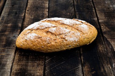 Tahta arka planda izole edilmiş baget ekmeği, kırsal kabuklu çörek üst görünümü, yiyecek ve içecek konsepti.