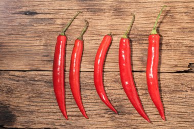Kırmızı biberli kırmızı biber koyu ahşap arka planda izole edilmiş. Yakın plan, üst görüş, yiyecek konsepti..