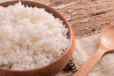 Kase pirinç beyazının ahşap arka planda kaşığı var.. 