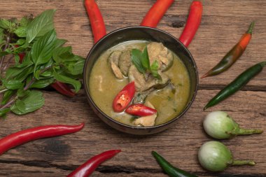 Yeşil tavuk körili patlıcan, ahşap arka planda fesleğen, üst manzara, Asya yemeği konsepti.