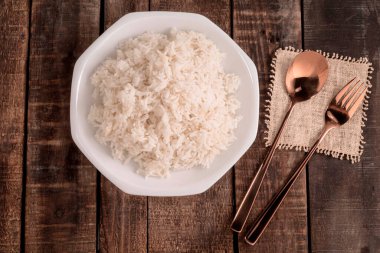 Kase beyaz pirinç ahşap arka planda kaşık içerir.. 