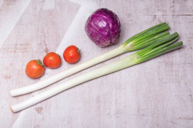 Pırasalı mor lahana ahşap arka planda izole edilmiş. Yakın plan, üst manzara, sebze besin konsepti..