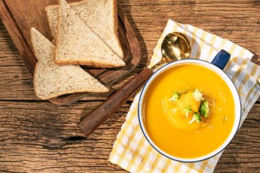 Kabak ezmesi ve havuç çorbası ahşap arka planda yakın plan, üst görüş, sağlıklı yiyecek konsepti.