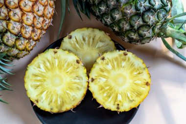 Pembe arka planda ananas dilimlenmiş tabak, üst manzara, sağlıklı meyve yemeği konsepti..