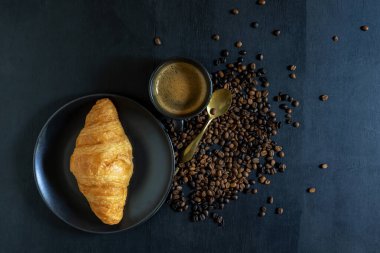 İzole edilmiş ahşap masa arkasında Espresso kahve ve kruvasan. Yakın plan, üst görüş, kahvaltı ve içecek konsepti..