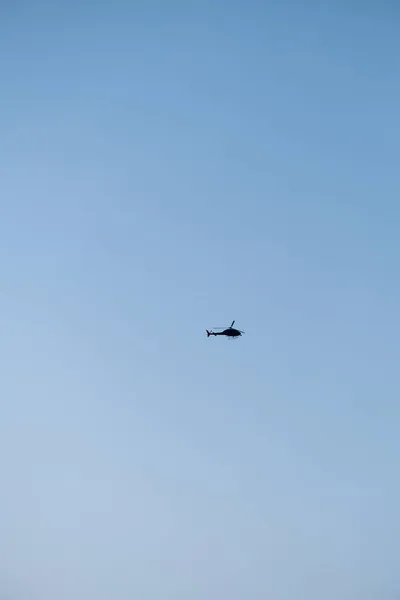 Helicóptero voando no céu azul. Silhueta de helicóptero no céu. Voando — Fotografia de Stock