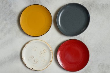 Renkli seramik tabakların düzlüğü, boş alanı olan temiz yemek çanağının üst görüntüsü.