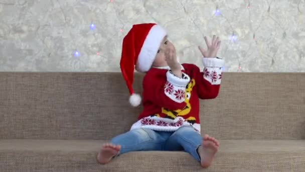 เด็กผิวขาวในวันหยุดคริสต์มาสในช่วงคริสต์มาส มีความสนุกสนานในบ้าน สุขสันต์วันคริสต์มาสและประเพณี — วีดีโอสต็อก
