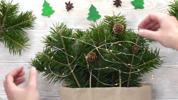 Décoration de maison de noël, pins branches avec anis et cônes vue de dessus plat, composition festive avec guirlande et plante verte sur table en bois avec jouets en forme d'arbre de noël — Video