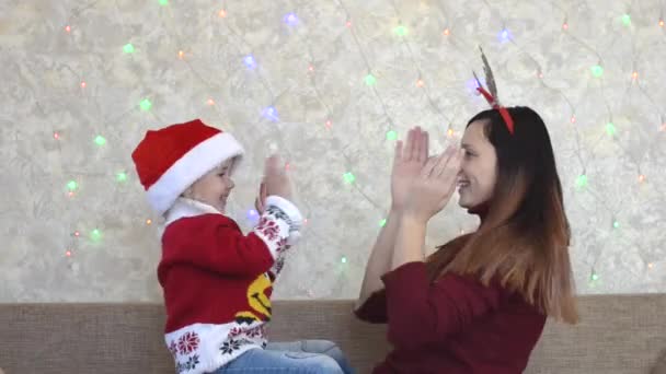 ครอบครัวผิวขาวที่มีความสุขที่บ้านในวันหยุดคริสต์มาส ใช้เวลาร่วมกัน ประเพณีคริสต์มาสที่แสนสุข แม่และลูกเล่นและสนุกด้วยกัน — วีดีโอสต็อก