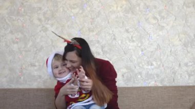 Mutlu Kafkas ailesi Noel tatillerinde evde birlikte vakit geçiriyor, mutlu Noel gelenekleri, anne ve çocuk oyun oynuyor ve birlikte eğleniyor.