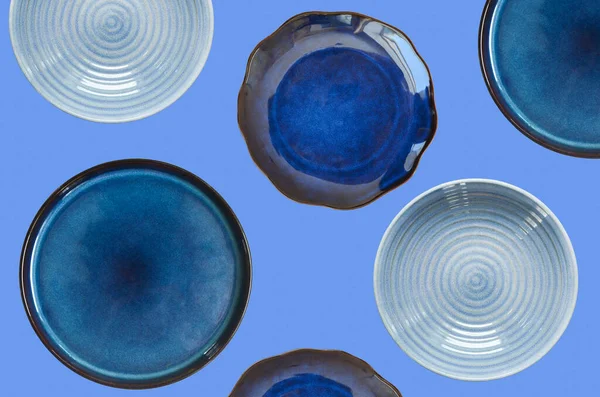 Schone lege handgemaakte keramische plaat geïsoleerd op blauwe achtergrond, gerechten voor uitgesneden en ontwerp, kopieerruimte en model sjabloon — Stockfoto