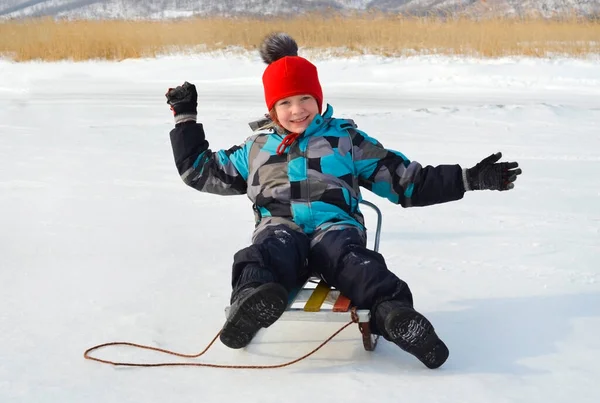 Кавказский ребенок в зимней одежде играет на открытом воздухе — стоковое фото