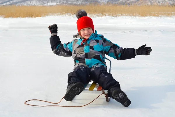 Niño caucásico en ropa de invierno jugando al aire libre —  Fotos de Stock