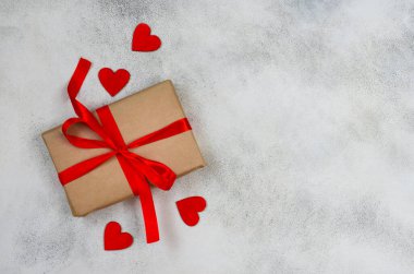Metinler için kopya alanı olan sevgililer günü arkaplanı, kırmızı kurdeleli bayram hediyesi kutusu ve ahşap süslemeler kalp şekli, ekolojik el işi paketi ve sıfır atık tatil.