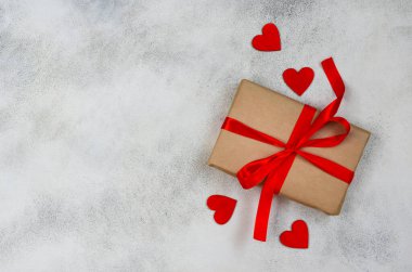 Metinler için kopya alanı olan sevgililer günü arkaplanı, kırmızı kurdeleli bayram hediyesi kutusu ve ahşap süslemeler kalp şekli, ekolojik el işi paketi ve sıfır atık tatil.