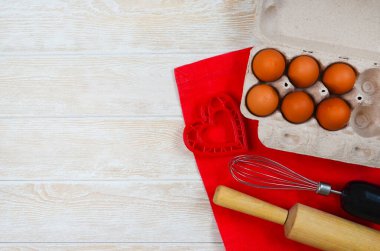 Yemek pişirmek için kırmızı şenlikli malzemeler, ekolojik pakette sevgililer günü yumurtaları, merdane ve çırpıcı, kek pişirmek için daha keskin çanak şeklindeki kalp..