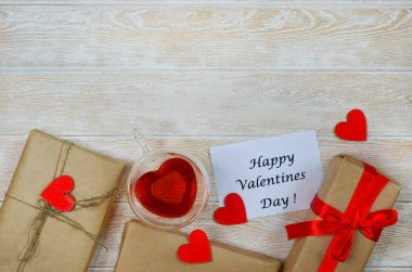 Sevgililer günü tebrik kartı, kırmızı kurdeleli ve ahşap süslemeli bayram hediyesi kutusu kalp şekli, çevreci el işi paketi ve sıfır atık bayram ve çay içeceği..