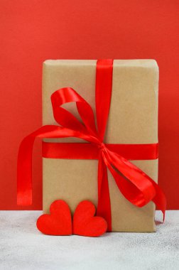 Sevgililer günü tebrik kartı, kırmızı kurdeleli ve ahşap süslemeli bayram hediyesi kutusu kalp şekli, ekolojik el işi paketi ve sıfır atık tatil.
