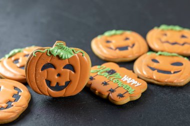 Siyah arka planda parlak cadılar bayramı kurabiyeleri