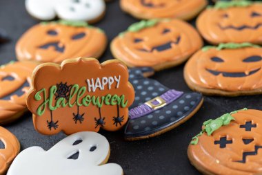 Siyah arka planda parlak cadılar bayramı kurabiyeleri