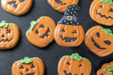 Siyah arka planda parlak cadılar bayramı kurabiyeleri