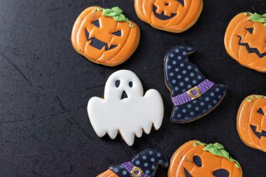 Siyah arka planda parlak cadılar bayramı kurabiyeleri