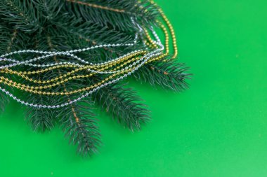 Yeşil bir zemin üzerinde ladin dalları, altın ve gümüş boncuklar Noel kompozisyonu.