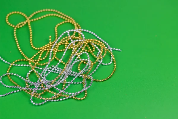 Composition de Noël de perles d'or et d'argent sur fond vert. — Photo