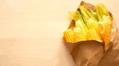 Beyaz ahşap arka planda bir buket gibi el işi kağıdında mısır. Metin için boşluk