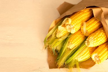 Beyaz ahşap arka planda bir buket gibi el işi kağıdında mısır. Metin için boşluk