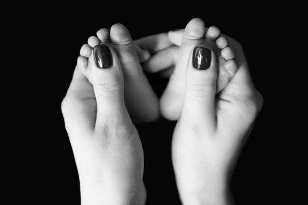 在黑色的背景上 妈妈手里拿着一张刚出生的小脚的黑白照片 妻子阵线 — 图库照片