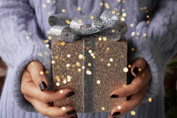 女性の手を保持クリスマスゴールドギフト輝くボックス ストック写真