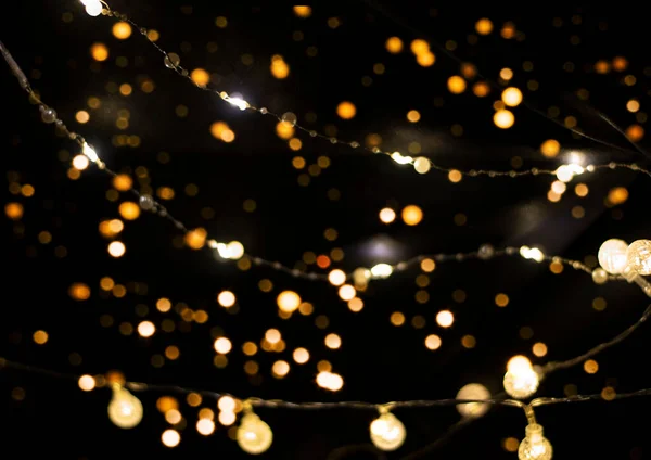 Bokeh e luzes festivas no fundo preto. — Fotografia de Stock