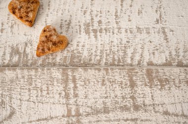 Ahşap arka planda iki kalp şeklinde kurabiye.