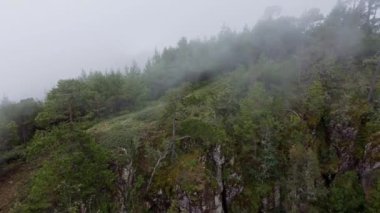 Una montaa que se esconde detrs de la densa niebla vespertina.