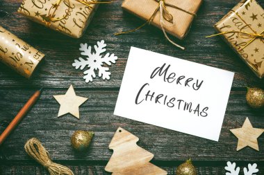 Mutlu noeller. Noel süslerini ve Noel tebrik kartlarını ahşap masada görebilirsiniz. Noel konsepti geçmişi