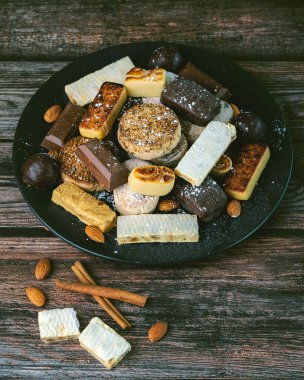 Nougat Noel tatlısı, mantekados ve polvoronlar ahşap masada. İspanya 'da tipik Noel tatlısı çeşitleri