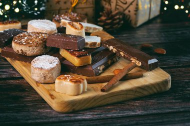 Nougat Noel tatlısı, mantekados ve polvoronlar ahşap masada. İspanya 'da tipik Noel tatlısı çeşitleri