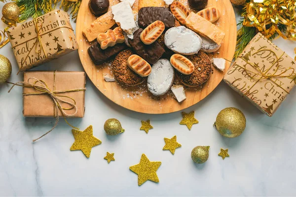 在大理石桌上放有圣诞装饰品的新圣诞甜品 曼陀罗和波沃罗内 西班牙典型的圣诞糖果的配售 — 图库照片