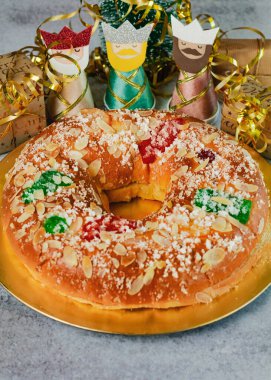 Kremalı Roscon de Reyes ve masada noel süsleri. Krallar Günü konsepti ispanyolca üç papaz pastası. Noel için tipik İspanyol tatlısı. Seçici odak