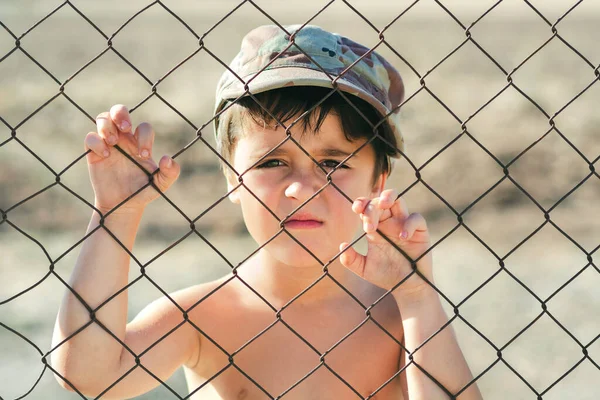 Triest Kind Met Een Militaire Pet Achter Een Hek Stop — Stockfoto