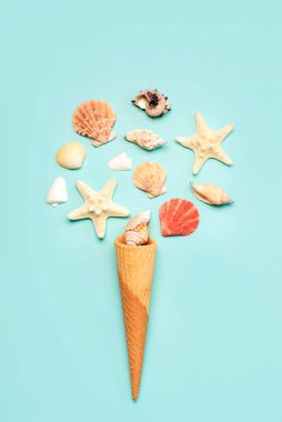 Mavi arka planda deniz yıldızı ve deniz kabuklu dondurma külahı. Yaz tatili kavramı