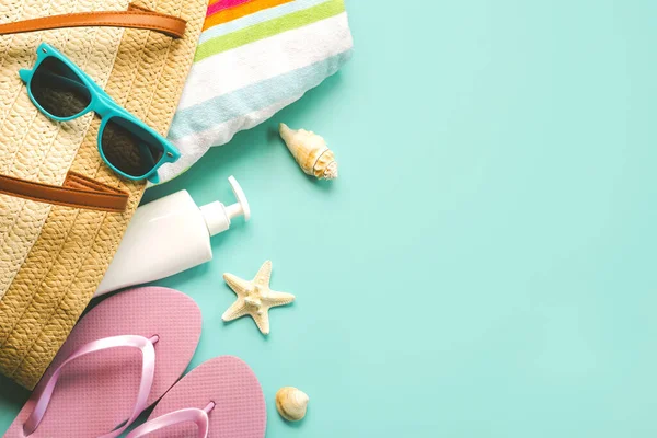 Yaz tatili kavramı. Terlik, plaj havlusu, güneş gözlüğü, deniz kabuğu, güneş kremi ve mavi arkaplan üzerine yazı yazmak için yeri olan deniz yıldızı manzarası.