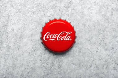 Gri arkaplanda izole edilmiş Coca Cola metal kapağının üst görünümü