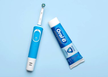 Elektrikli diş fırçası Oral-B Vitality ve Oral B diş macunu mavi arkaplan üzerinde