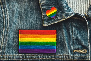 Kot ceket ve LGTBI pin kalp şeklindeki LGTBI marka tekstil bandının yakın çekimi. Gurur Günü konsepti