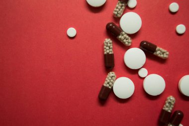 Masanın üzerinde farklı şekillerde tabletler ve termometre var. 