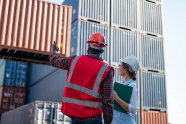 Foreman kontrol kargo nakliye gemisinden ithalat için konteynır kutusu yüklüyor. Deniz limanında nakliye konteynırları.